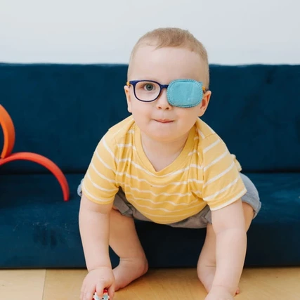 malý chlapec s prekrytým ľavým okom na okuliaroch tupozrakosť